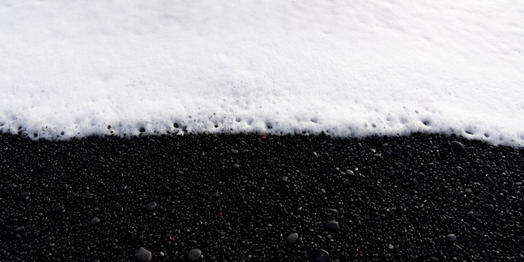 Juxtaposition photography examples - white sea foam and black beach